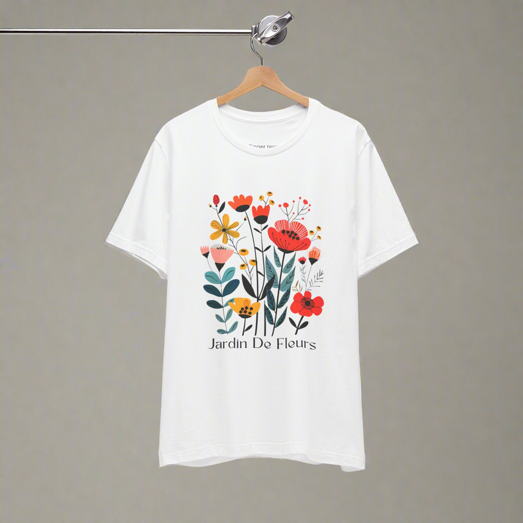 White t-shirt with a colorful floral design and the text 'Jardin De Fleurs' at the bottom. The design features various flowers in red, orange, yellow, and pink hues with green leaves, creating a vibrant garden look.