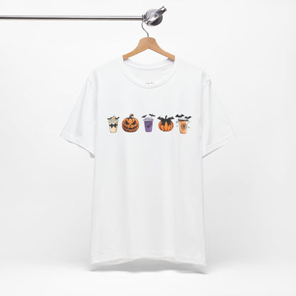 white t-shirt featuring five Halloween-themed coffee cups and pumpkins with bats, perfect for coffee lovers and Halloween enthusiasts seeking a fun, spooky vibe.