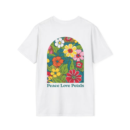 A white t-shirt laid flat with a retro pop art floral design on the back. The design features bold, colorful flowers in an arched frame with the words "Peace Love Petals" in vintage-style lettering. The shirt has a cheerful, 70s-inspired aesthetic and is styled on a neutral-toned background.