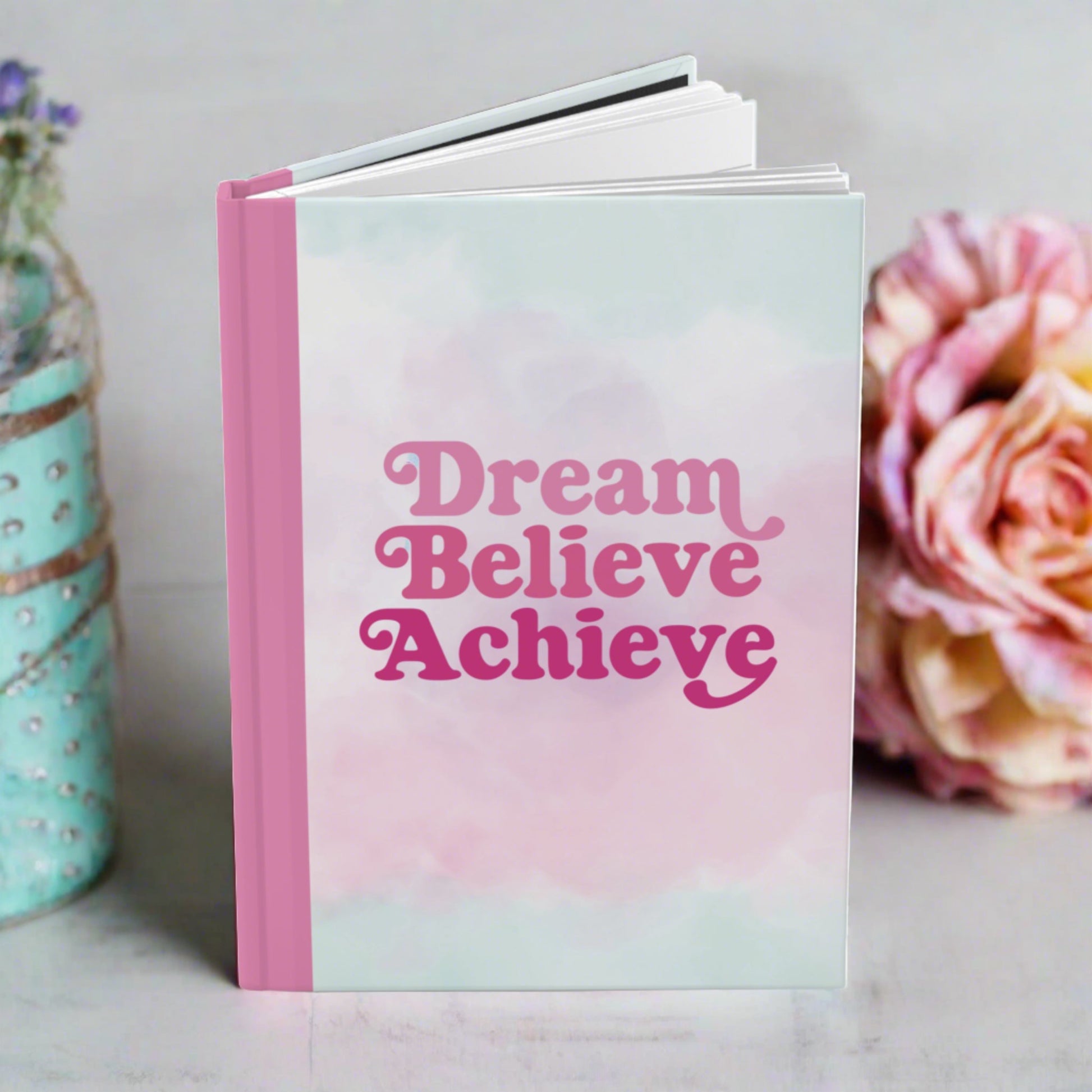 Dream believe achieve hardcover journal standing on a table with pastel vibes