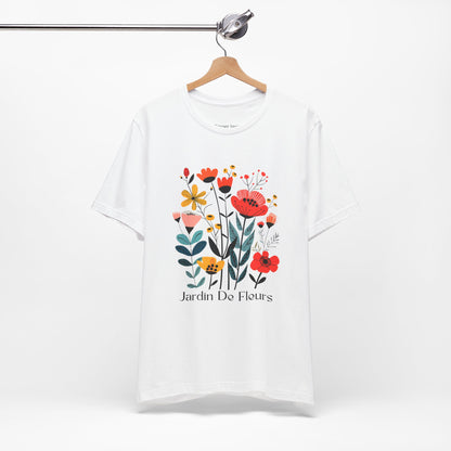 White t-shirt with a colorful floral design and the text 'Jardin De Fleurs' at the bottom. The design features various flowers in red, orange, yellow, and pink hues with green leaves, creating a vibrant garden look.