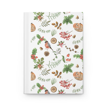 journal cover with a delicate watercolor pattern of woodland plants, berries, and a sleeping chipmunk, alongside holly leaves, pinecones, and a bullfinch bird on a white background.